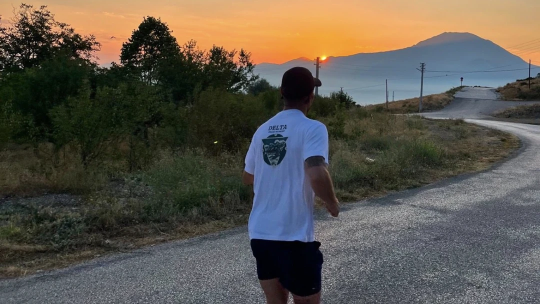 Gün batımında dağ yolunda koşan bir ekip üyesi